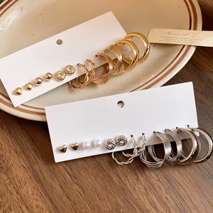 Detailed view of a multi-piece earring set featuring golden and silver heart and hoop designs.