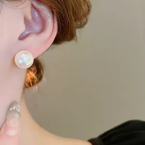 Elegante dettaglio ravvicinato di un grande orecchino a perla bianca con luce soffusa