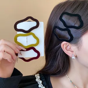 Close-up of stylish flocked irregular geometric hair clips in autumn colors on a model