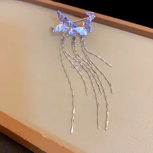 Close-up of an elegant butterfly tassel ear cuff with delicate silver chains on jewelry tray