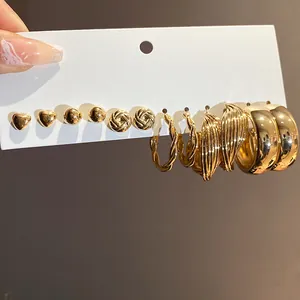 Detailed macro view of multi-style golden earring set with heart and twisted hoop designs