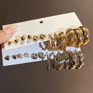 Detail view of gold and silver earring set with heart and twisted hoop designs