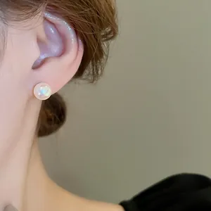 Elegante orecchino a perla iridescente mostrato su modella in stile francese minimalista