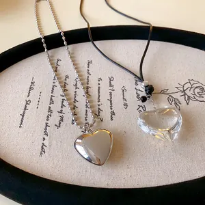 Detailed macro view of silver and transparent heart-shaped necklaces on vintage plate