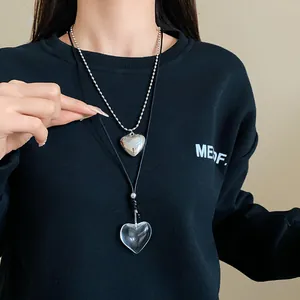 Detail view of minimalist silver and clear glass heart pendant necklaces for women