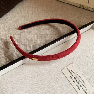 Close-up detail of a red flocked thin headband with elegant gold "Love" charm accent