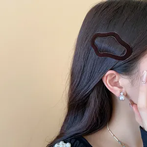Close-up showing a brown flocked irregular geometric hair clip styled on model hair