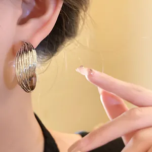 Detail shot of elegant silver twisted hoop earrings worn by a model for a chic look