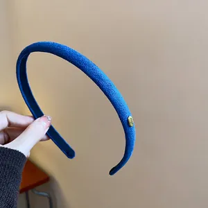 Close-up of blue flocked headband featuring a gold 'Love' engraved metal piece