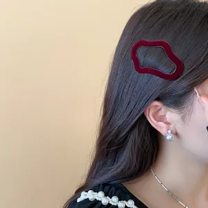 Detailed view of a burgundy flocked geometric hair clip styled on long black hair