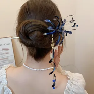 Detalle de un elegante palillo para el cabello de esmalte azul con flecos dorados