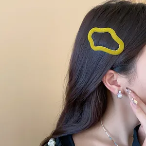 Close-up detail of a yellow flocked irregular geometric hair clip for women