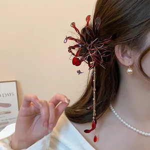 Detalle exquisito de una horquilla de lirio araña rojo con borlas para trajes Hanfu