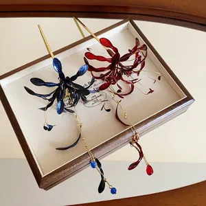 Detalle de horquillas Lycoris esmaltadas con borlas doradas largas y elegantes.