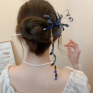 Detalle de elegante horquilla de flor de licoris azul con borlas en peinado moño