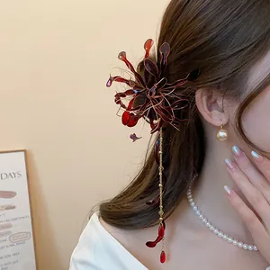 Detalle de una horquilla vintage con lirio araña rojo y borlas puesta en el cabello
