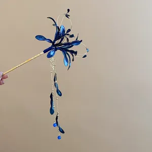 Detalle de horquilla de lirio de araña azul con elegantes borlas doradas y cuentas.