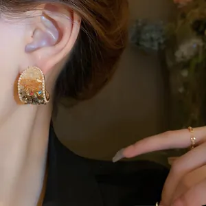 Close-up view of vintage French style earrings with pearls and amber crystals on a model