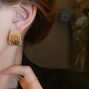 Detail view of French vintage crystal pearl stud earrings with amber gradient finish.