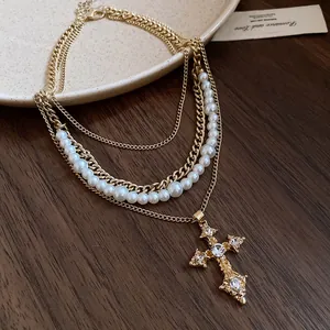 Close-up of vintage multi-layer necklace with pearls and rhinestone cross pendant