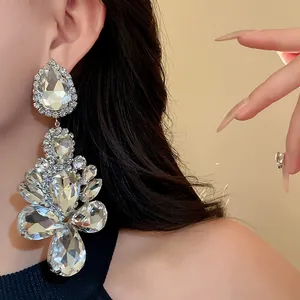 Close-up of large rhinestone teardrop dangle earrings on model