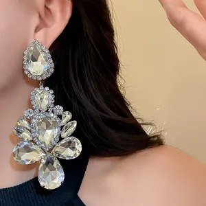 Close-up detail of silver-tone teardrop rhinestone statement earrings for elegant evening wear