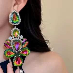 Detailed view of oversized iridescent teardrop chandelier earrings with rhinestones