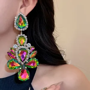 Exquisite detail view of oversized multicolor teardrop crystal earrings worn by a model