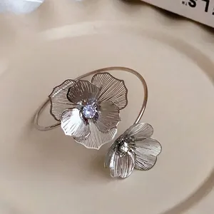 Elegant silver flower open bangle bracelet featuring a sparkling purple crystal center.