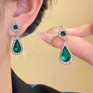 Elegant vintage emerald green teardrop earrings with shimmering crystal halo accents