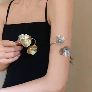 Detail shot of elegant floral open bangle with sparkling rhinestones on model's arm.