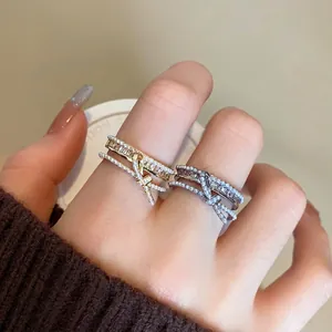 Primo piano di eleganti anelli a strati in oro e argento con zirconi e piccole perle