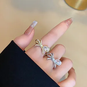 Vista dettagliata di scintillanti anelli a fiocco in zirconia placcati oro e argento
