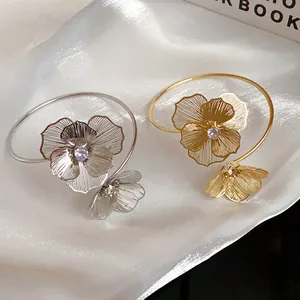 Detailed view of elegant gold and silver floral open bangles featuring sparkling central rhinestones