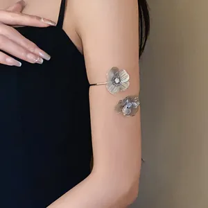 Detail shot of an elegant floral open arm cuff with sparkling rhinestones on the arm.