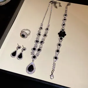 Close-up view of a vintage jewelry set with black teardrop pendant and sparkling rhinestones