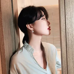 Close-up of elegant square zirconia geometric stud earrings worn by an Asian model