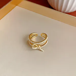 Macro dettagliata dell'anello a fiocco placcato oro con perle e zirconi