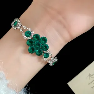 Macro view of vintage silver bracelet featuring emerald green crystal flower design