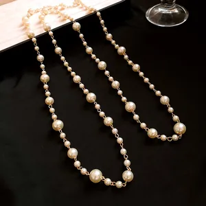 Elegant long layered faux pearl necklace with gold chain detail on black background