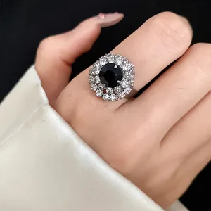 Close-up of a vintage flower ring with a large black gemstone and white crystal halo.