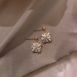 Detail shot of geometric gold earrings inlaid with sparkling clear cubic zirconia stones