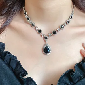 Detail view of a vintage-style necklace with black waterdrop rhinestones on a model.