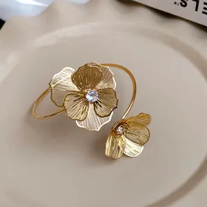 Exquisite close-up showing the intricate floral texture and crystal of a gold bangle