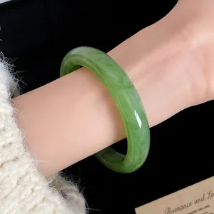 Vista dettagliata di un elegante bracciale in resina marmorizzata verde indossato al polso, stile