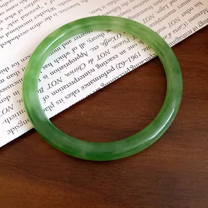 Elegante bracciale rigido in resina verde venata con un design liscio e minimale