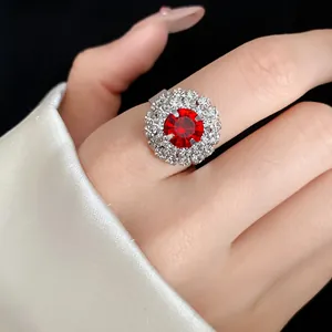 Close-up of a vintage luxury flower ring with a large red stone and double diamond halo.