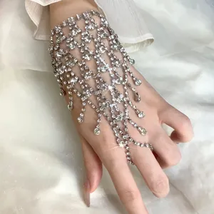 Close-up of elegant rhinestone multi-layer tassel hand chain on white silk background