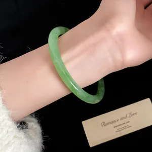 Primo piano di un braccialetto in resina marmorizzata verde indossato al polso elegante