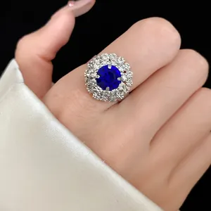 Macro view of luxury royal style blue sapphire halo flower ring on female hand
